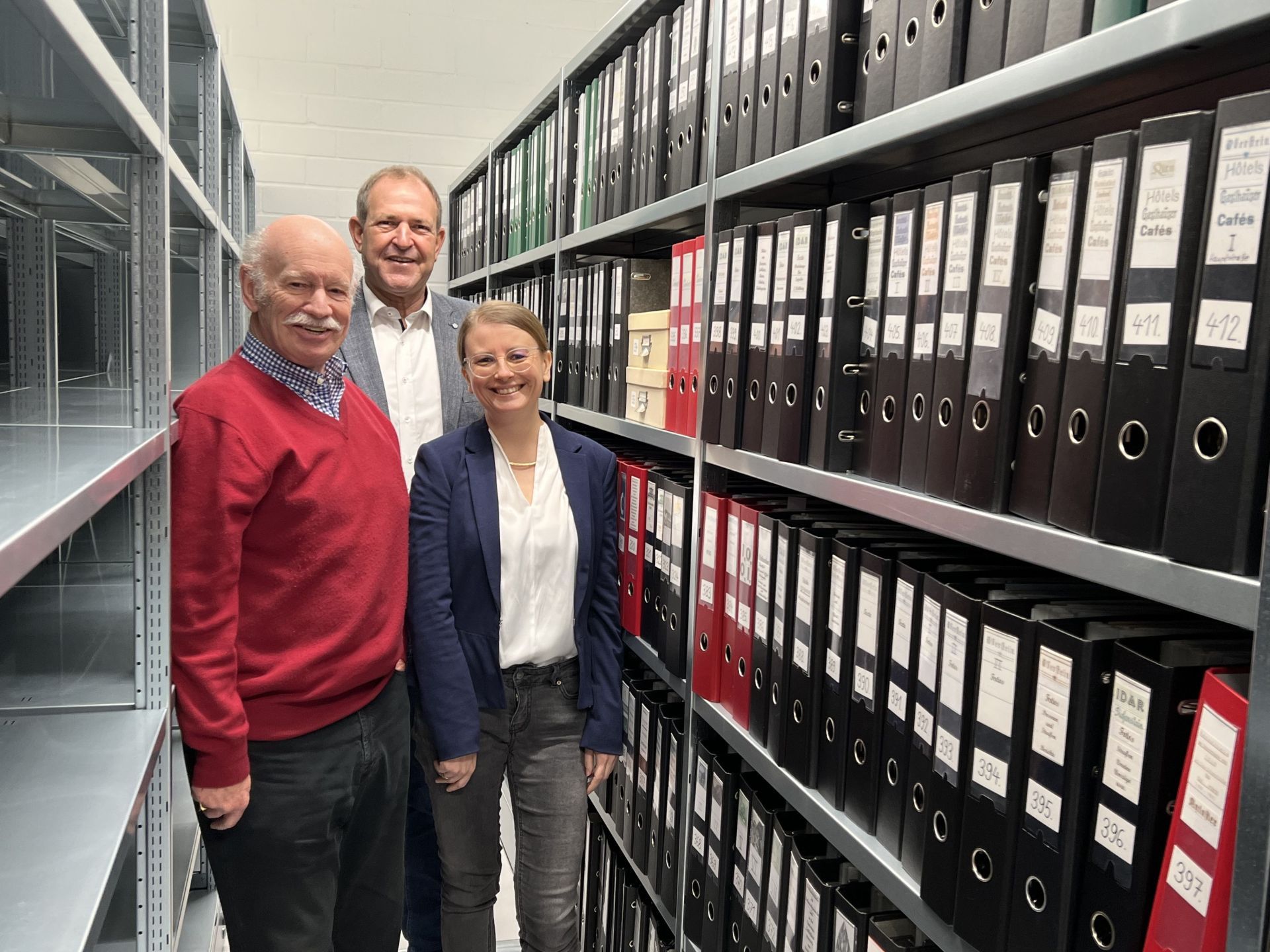 La photo montre le maire Frühauf, Dieter Jerusalem et l'archiviste de la ville, Dr. Svenja Müller, parmi de nombreux dossiers de la collection.