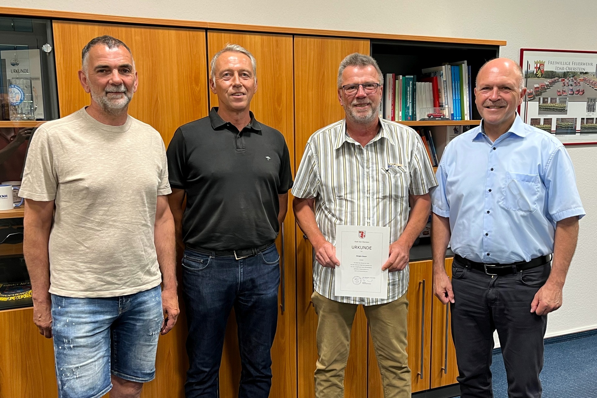 La photo montre les personnes mentionnées dans le bureau du maire Marx. Jürgen Sauer tient le certificat de remerciement entre ses mains.