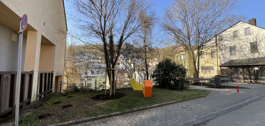 L'espace vert nouvellement aménagé au 41 Wasenstraße a également été équipé de sièges. La photo montre l'espace vert réaménagé avec deux nouveaux sièges de couleur jaune et orange.