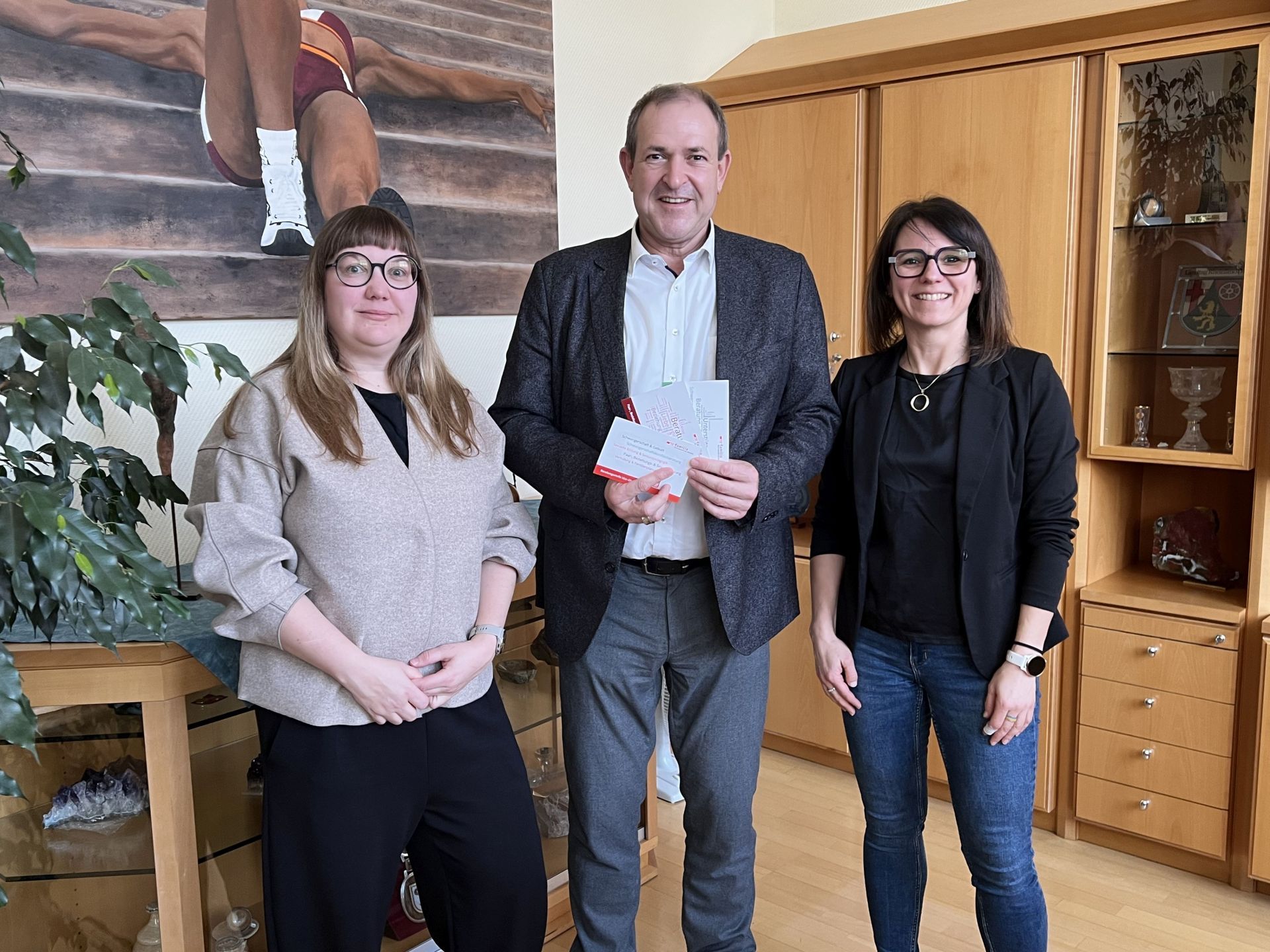 La photo montre les employées de pro familia d'Idar-Oberstein et du bureau du Land Main avec le maire Frühauf.