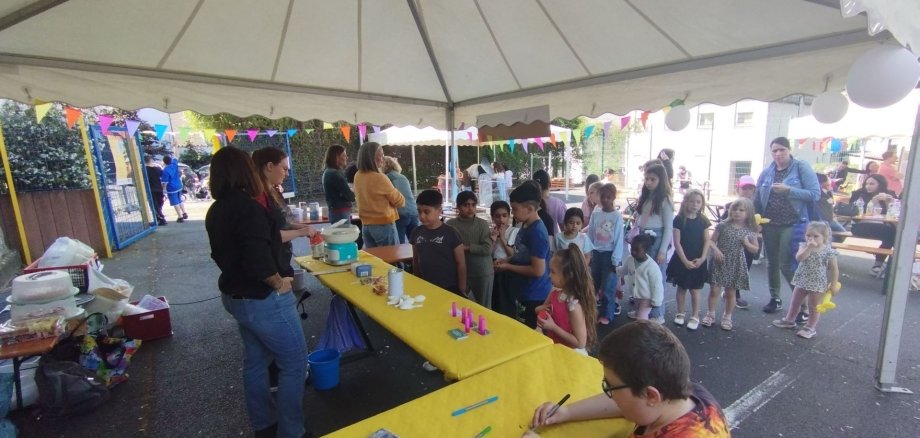 De nombreux enfants ont visité la Wasenfest et se sont bien amusés par beau temps. De nombreux enfants attendent au stand de Diakonie.