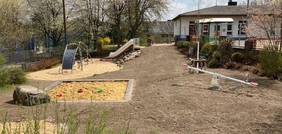 Das Foto zeigt einen Blick auf Spieplatz Barbararing mit Sandkasten, Wippe, Rutsche und Klettergerät.