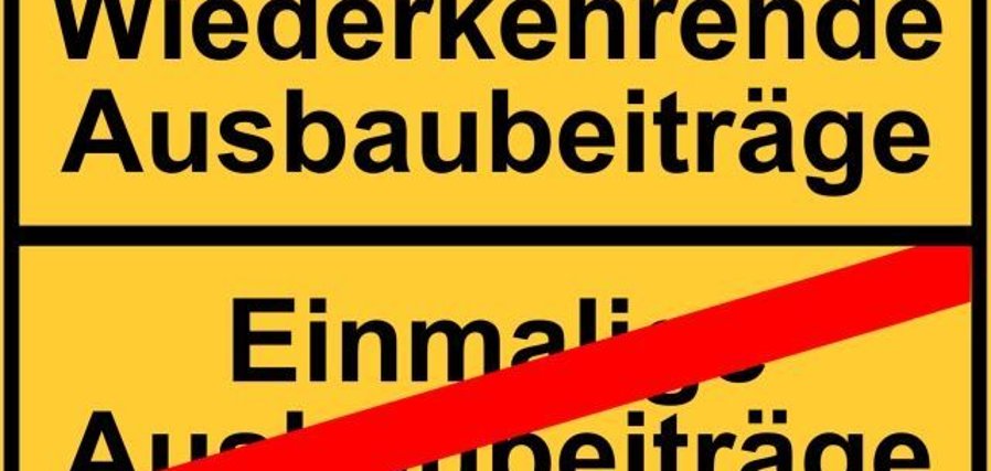 Das Foto zeigt ein stilisiertes Ortsschild. Im oberen Bereich steht Wiederkehrende Ausbaubeiträge, im unteren Bereich durchgestrichen Einmalige Ausbaubeiträge.