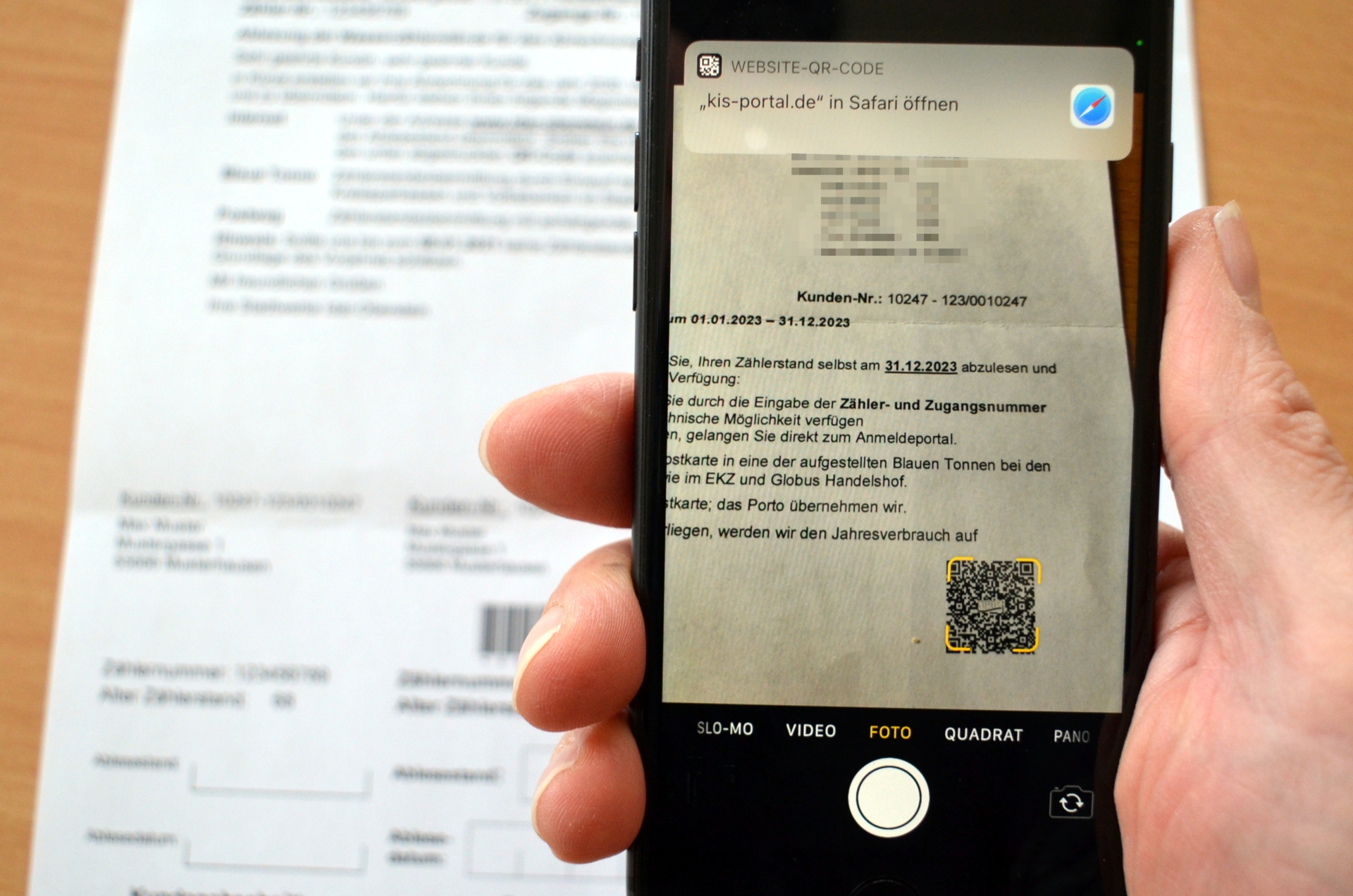 Das Foto zeigt ein Smartphone. Es wird über die Ablesekarte gehalten und scannt den QR-Code, der zur Zählerstandsmeldung auf der städtischen Homepage führt.