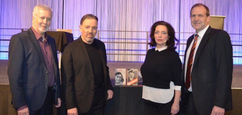 Das Foto zeigt die genannten Personen, die nebeneinander vor der Bühne in der Messehalle stehen und in die Kamera schauen.