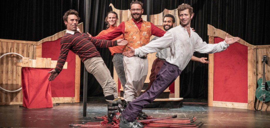 Das Foto zeigt die fünf Künstler der Gruppe Kakavresky, die auf Skiern in einer Zirkusmanege stehen.