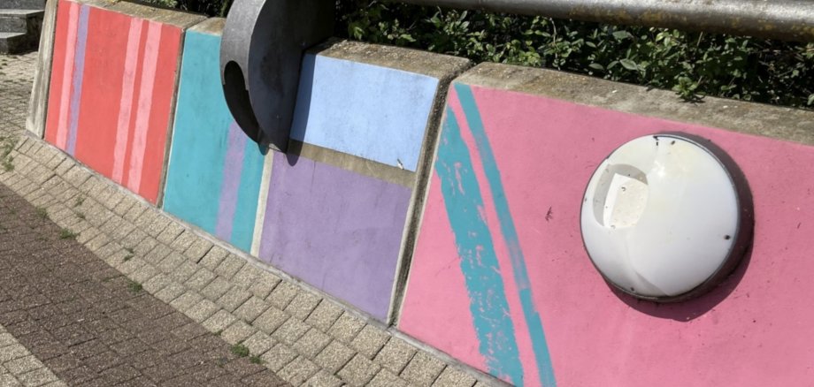 Das Foto zeigt eine beschädigte Leuchte an einem Fußweg.