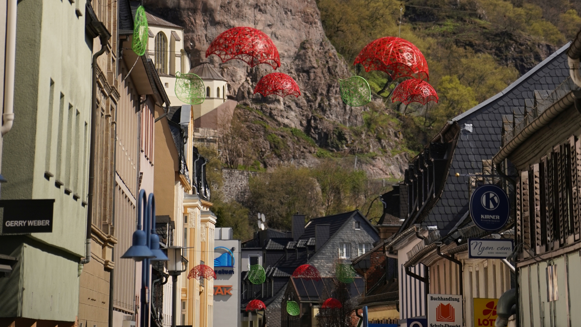 Das Foto zeigt die Dekoartikel, die an Drahtseilen zwischen den Häusern der Fußgängerzone Oberstein hängen.