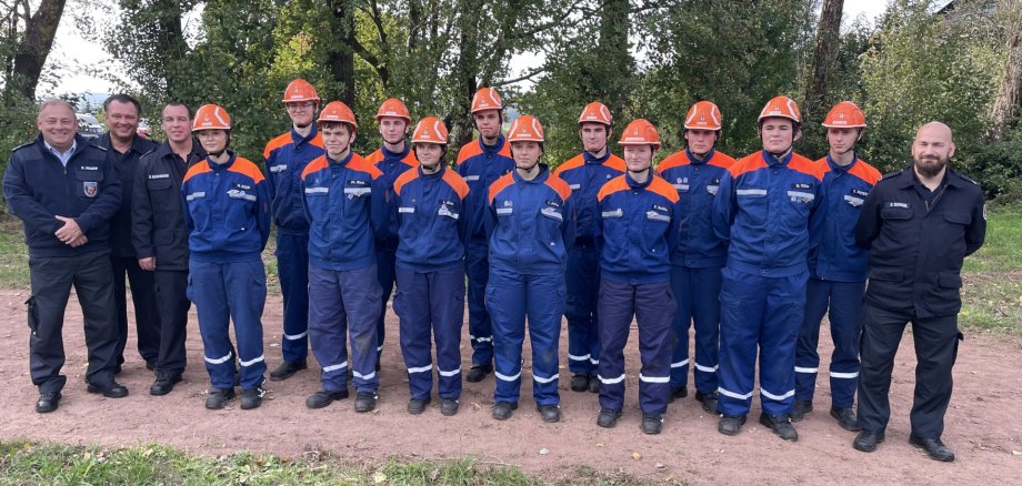 Das Foto zeigt ein Gruppenbild der Teilnehmer. Sie stehen mit ihren Feuerwehruniformen nebeneinander im Freien.