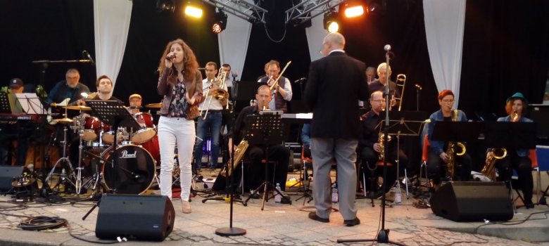 Das Foto zeigt die Band zusammen mit der Sängerin Julia Oschweski auf der Bühne am Schleiferplatz bei den Jazztagen Idar-Oberstein.