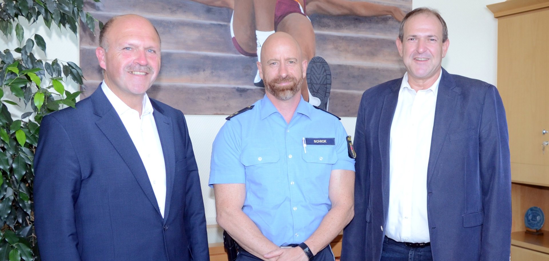 Das Foto zeigt die genannten Personen, die im Dienstzimmer des Oberbürgermeisters vor einem Gemälde stehen.
