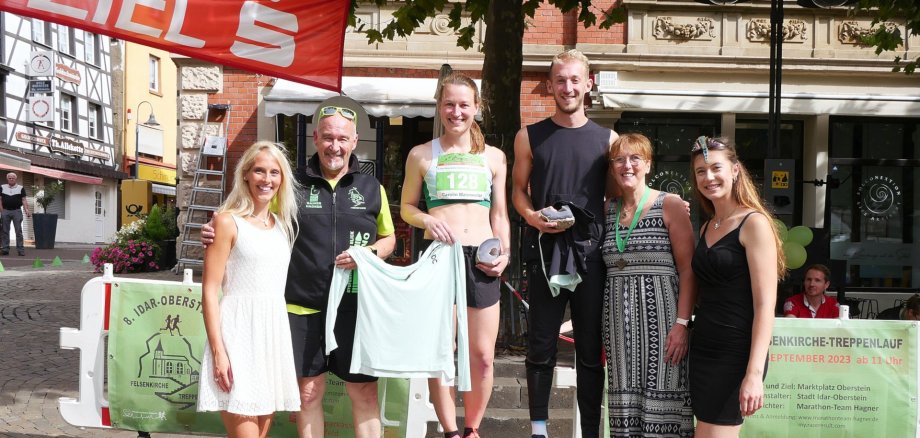 Das Foto zeigt die genannten Personen, die nebeneinander auf dem Siegerpodest stehen.