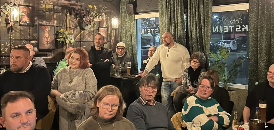 Eine Gruppe Interessierter Menschen sitzt zusammen und diskutiert Ideen