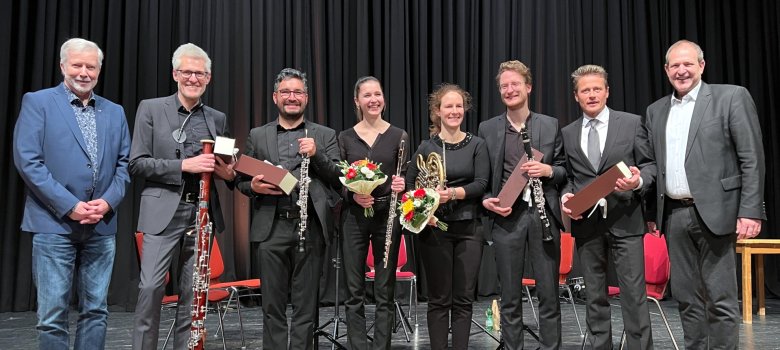 Die Protagonisten stehen nebeneinander auf der Bühne des Stadttheaters und schauen in die Kamera.