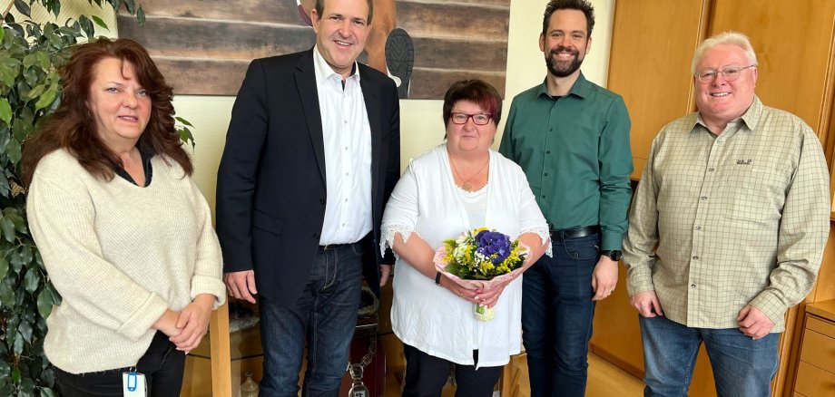 Das Bild zeigt Christiane Mernberger, die verabschiedet wird, den Oberbürgermeister und Kollegen. 