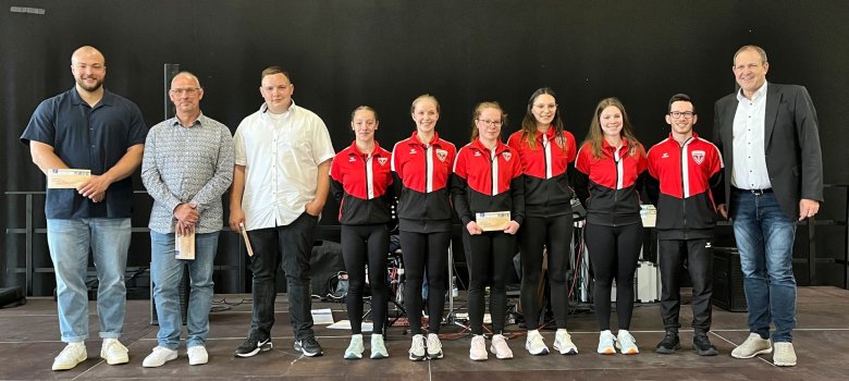 Das Foto zeigt die geehrten Sportlerinnen und Sportler zusammen mit Oberbürgermeister Frühauf. Sie stehen nebeneinander auf der Bühne und schauen in die Kamera.