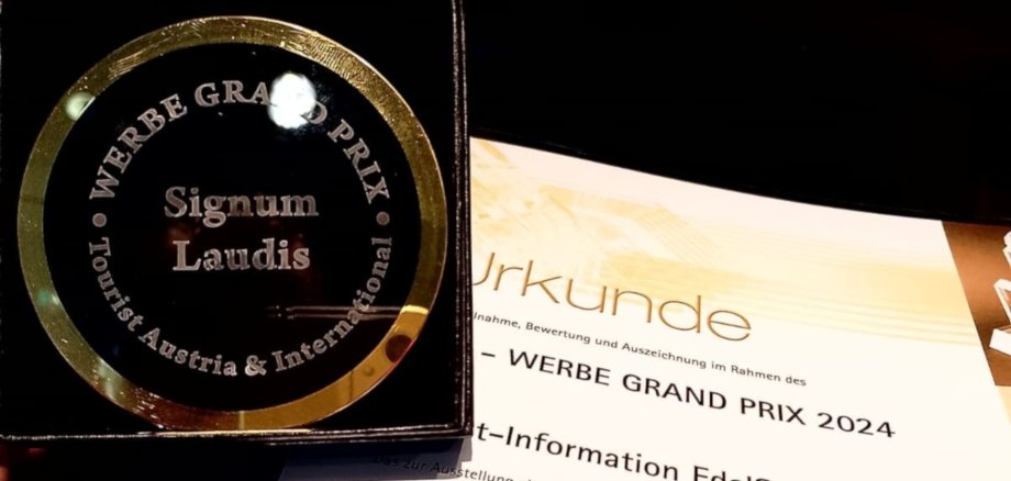 Das Foto zeigt den Preis, eine Medaille aus Glas, und die Urkunde.
