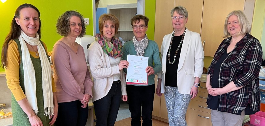 Das Bild zeigt die Akteure des Projektes bei der Übergabe des Zertifikates an die Kita-Leiterin Silke Fritsch durch Irmgard Lüttiken. Mit ihr freuen sich rin Silke Fritsch (3. v. l.). Mit ihnen freuten sich Tina Weber, Anja Pullem, Katrin Schwarz und Kita-Fachberaterin Juliane Groß.