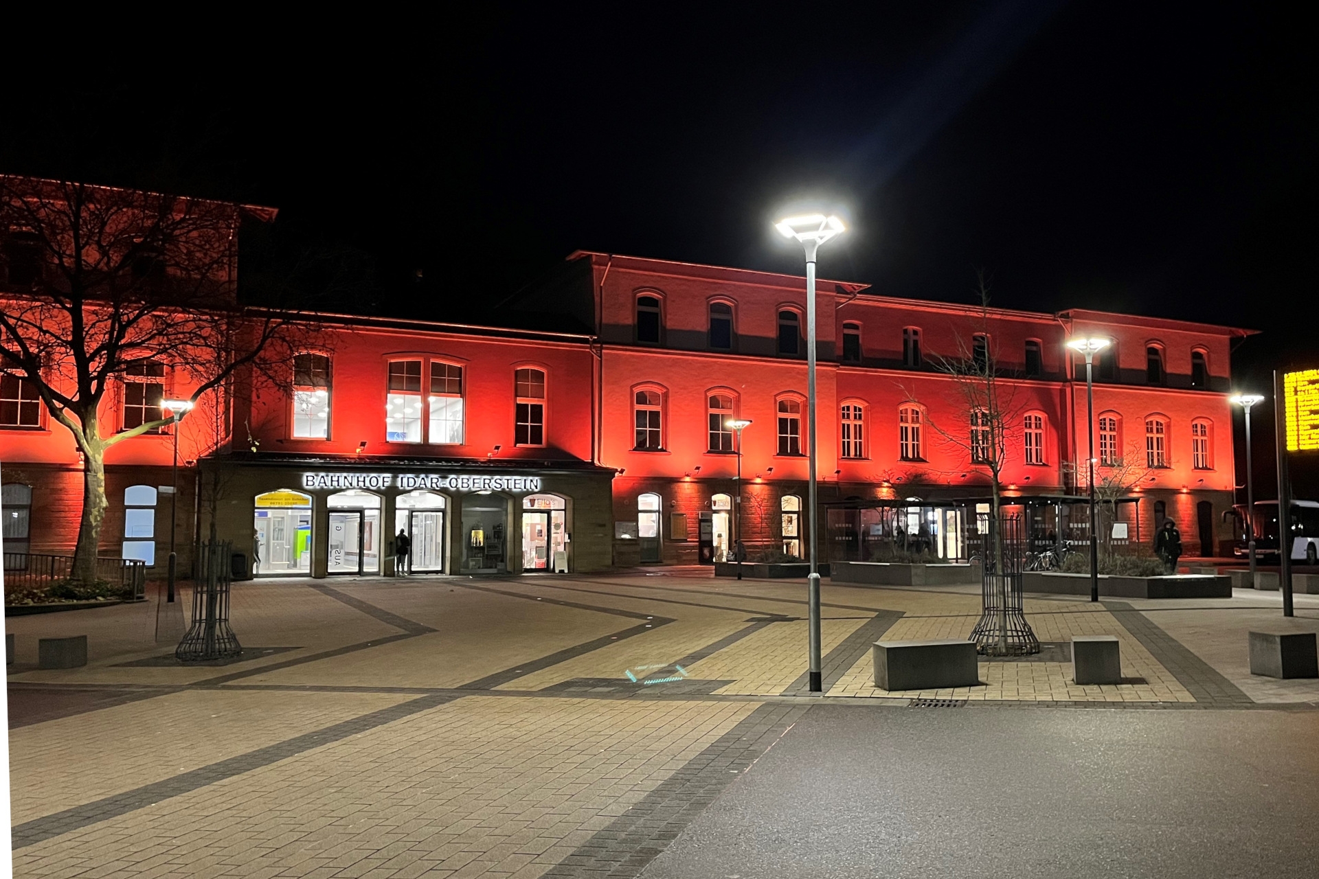 Das Foto zeigt den Bahnhof Idar-Oberstein, der orange angestrahlt wird.