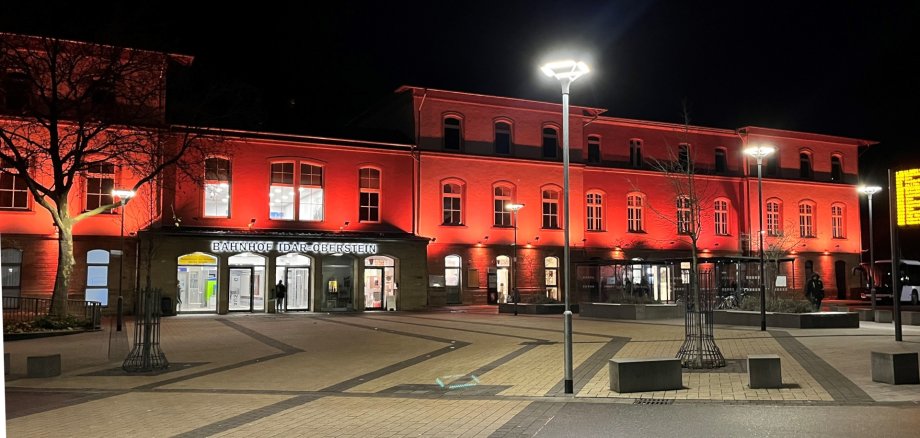 Das Foto zeigt den Bahnhof Idar-Oberstein, der orange angestrahlt wird.