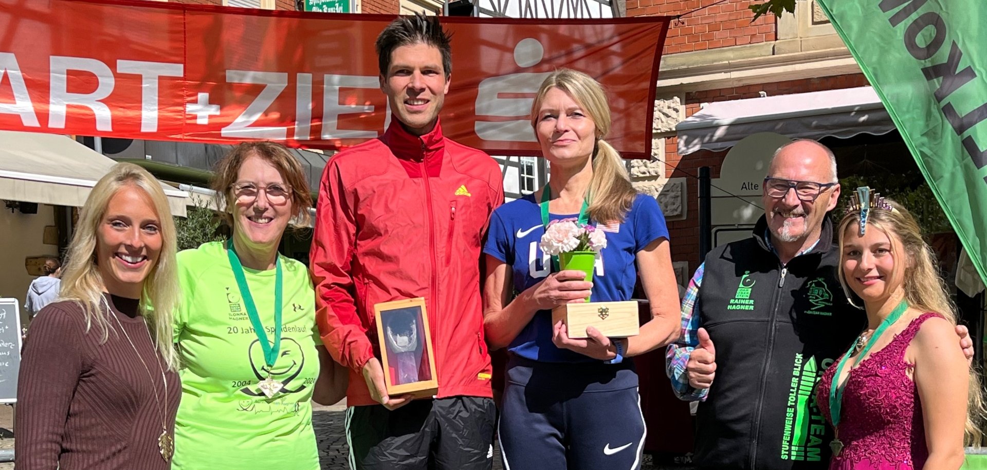 Das Foto zeigt die Gewinner, die auf dem Siegerpodest stehen. Sie werden eingerahmt vom Marathonteam Hagner, der Deutschen Edelsteinkönigin sowie Bettina Reiter, der 2. Vorsitzenden des Fördervereins Deutsche Edelsteinstraße.
