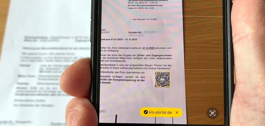 Über den QR-Code auf der Ablesekarte kommen die Kunden direkt zur Zählerstandsmeldung. Das Foto zeigt ein Handy, mit dem der QR-Code auf der Ablesekarte gescannt wird.