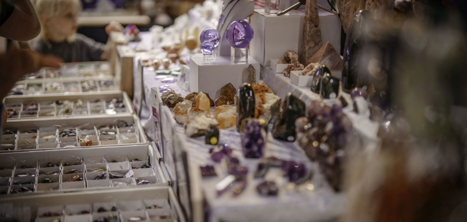 Das Foto zeigt einen Stand auf einem früheren Edelsteinschleifer- und Goldschmiedemarkt mit Schuckstücken. 