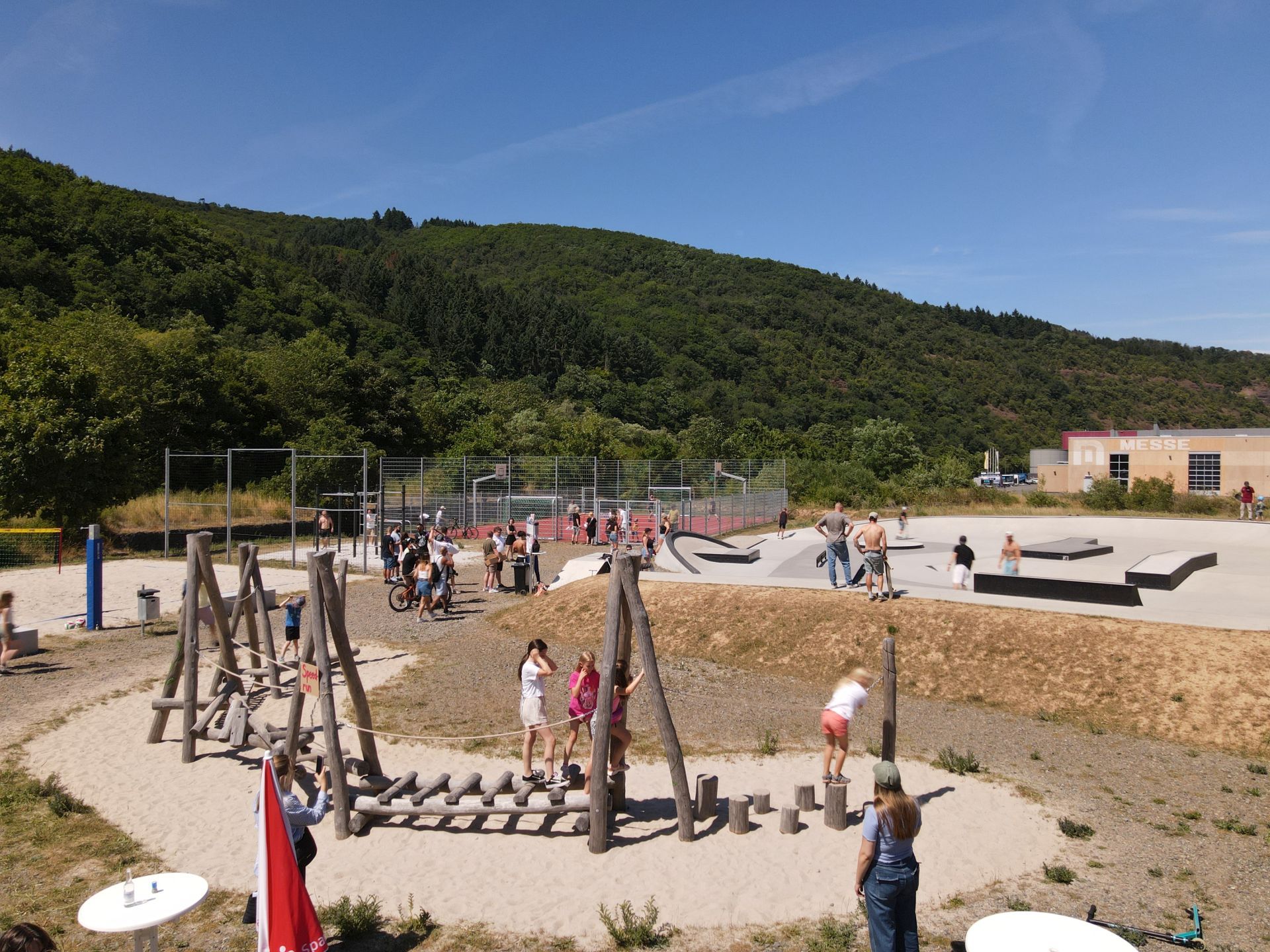 Das Foto zeigt den Stadtpark während des Sommerfestes bei gutem Wetter und vielen Kindern und Jugendlichen auf den Spielgeräten. 