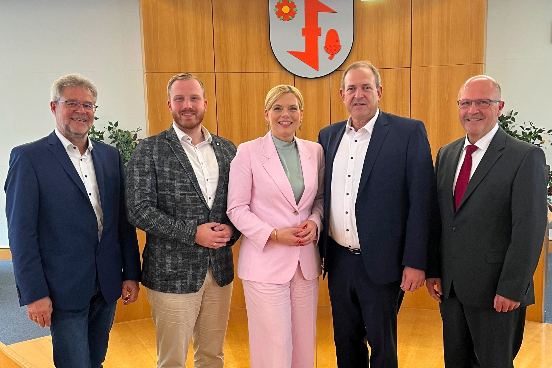 Das Foto zeigt die genannten Personen. Sie stehen im Sitzungssaal nebeneinander und schauen in die Kamera.