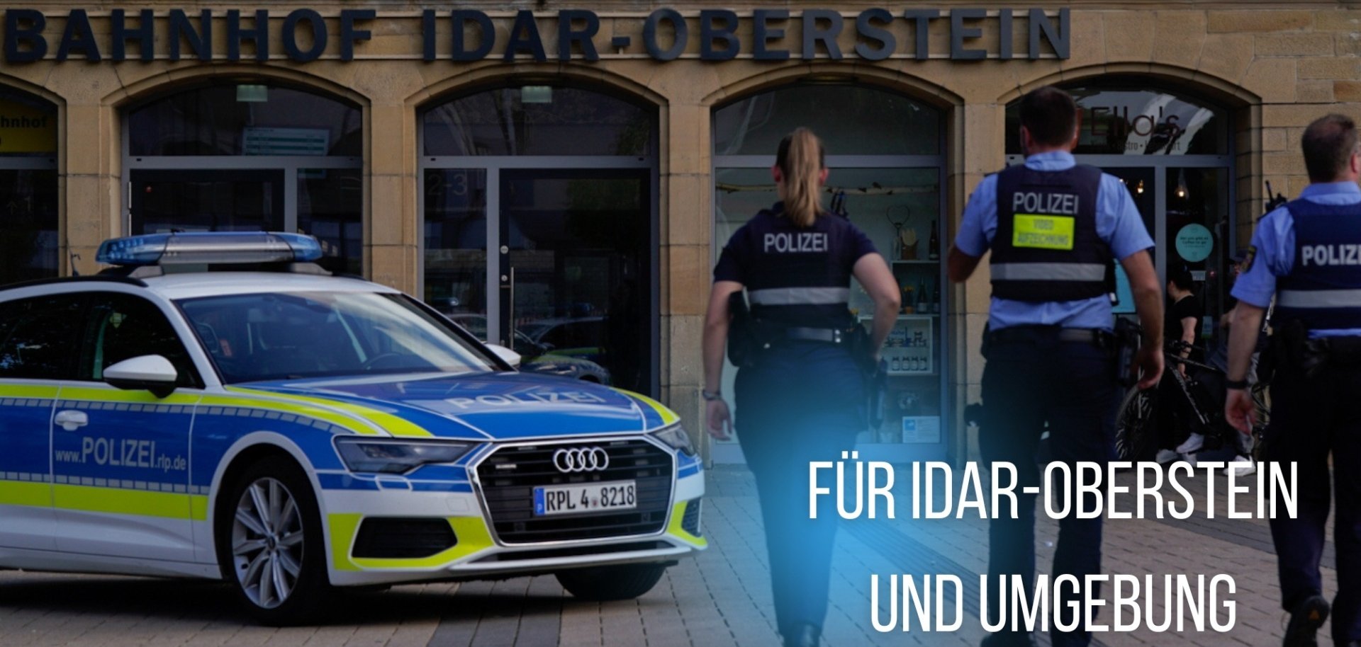 Das Foto zeigt drei Polizisten und ein Polizeiauto vor dem Bahnhof Idar-Oberstein.