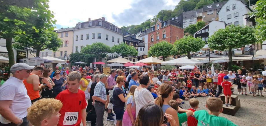 Das Foto zeigt den Obersteiner Marktplatz mit vielen Läufern und Zuschauern im Anschluss an den Altstadtlauf vor der Siegerehrung. 