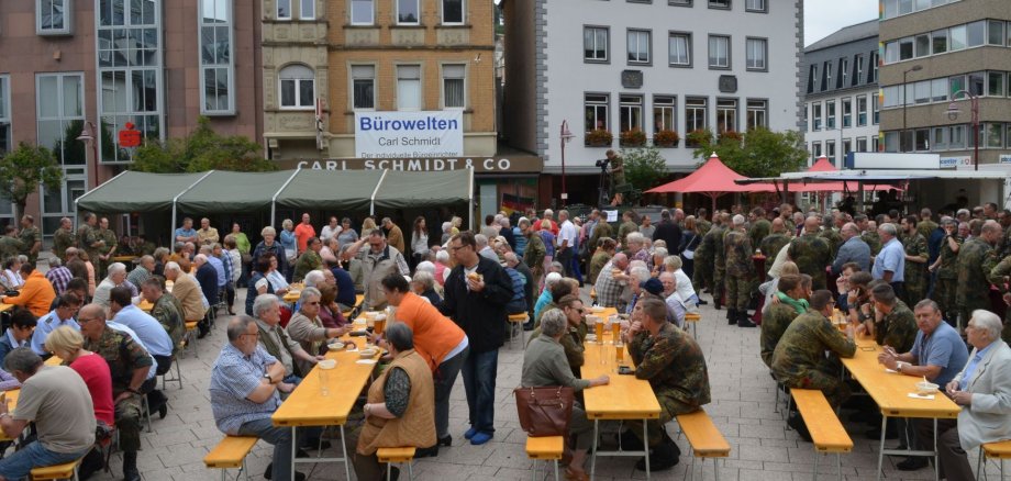 Das Foto zeigt viele Bürgerinnen und Bürger, die mit Soldaten feiern. 