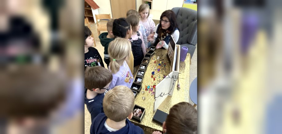 Das Foto zeigt die Autorin, die den Kindern vor dem Kamishibai Edelsteine zeigt.