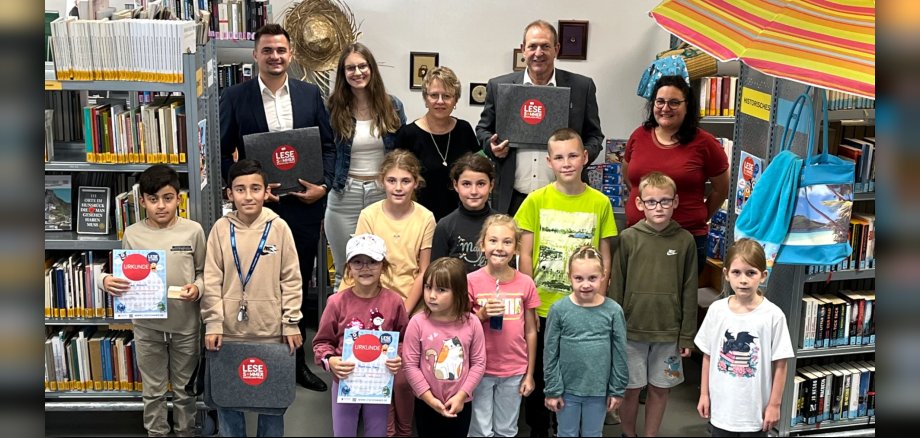 Das Foto zeigt OB Frühauf, Sandra Ley, ehrenamtliche Helferinnen, Niklas Jahke von der KSK Birkenfeld und Kinder in der Stadtbibliothek.