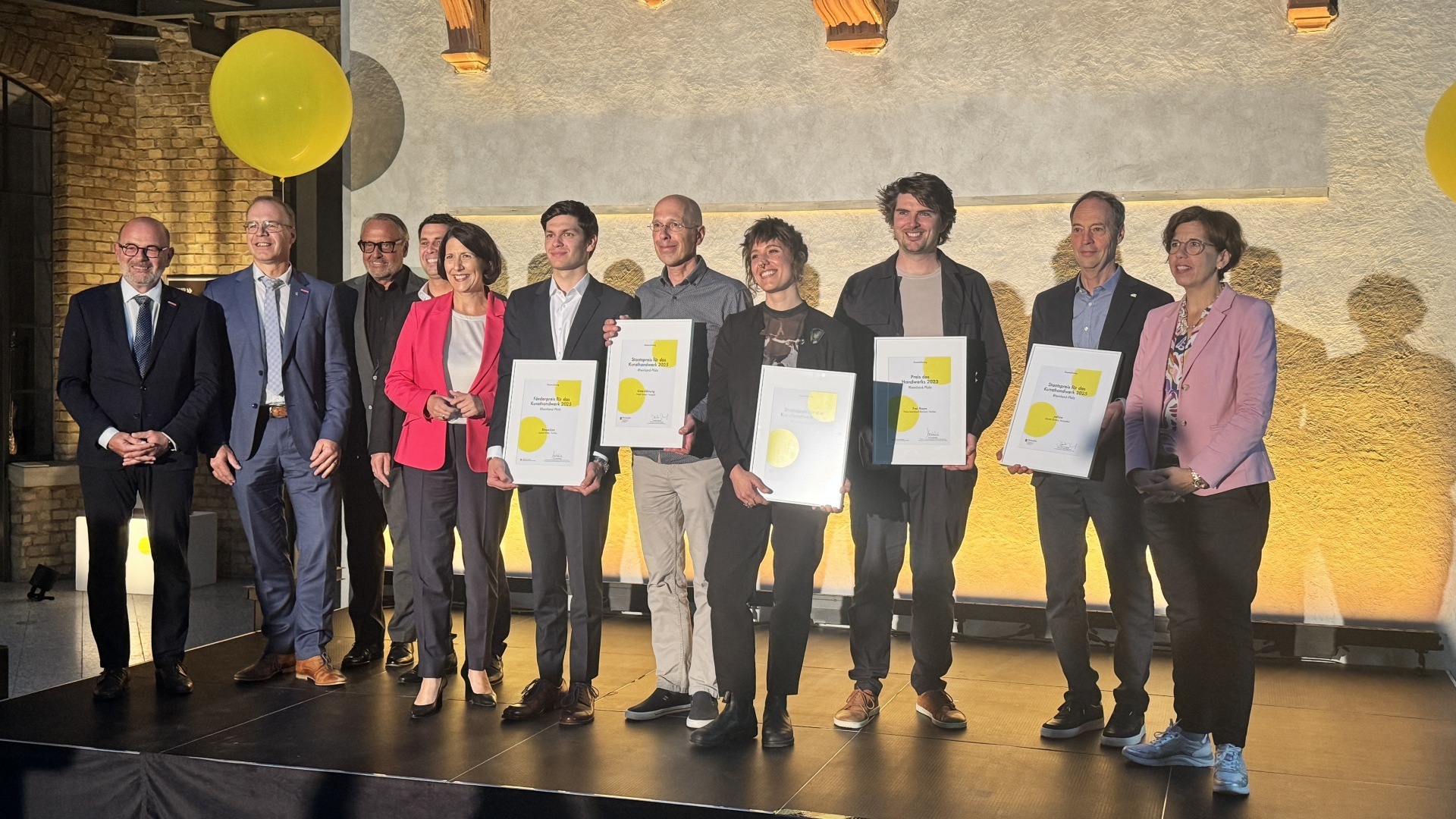 Das Foto zeigt die Preisträger sowie Vertreter des Ministeriums und der Handwerkskammer auf der Bühne.