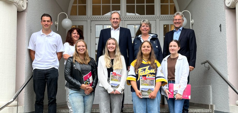 Das Foto zeigt die genannten Personen. Sie stehen in zwei Reihen auf der Treppe vor dem Stadthaus. Die neuen Mitarbeiterinnen stehen in der vorderen Reihe.