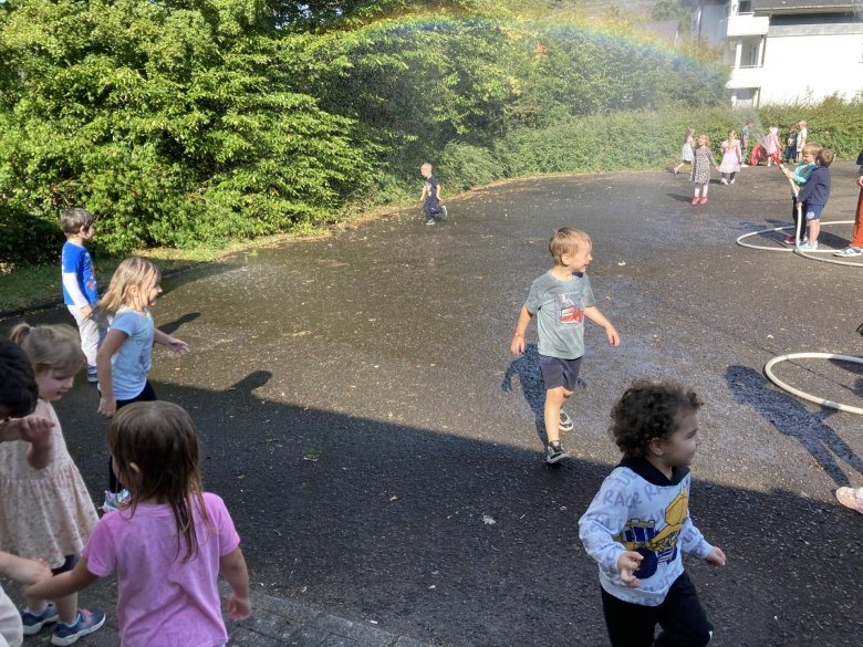 Das Foto zeigt die Kinder beim spritzen mit den Wasserschläuchen.