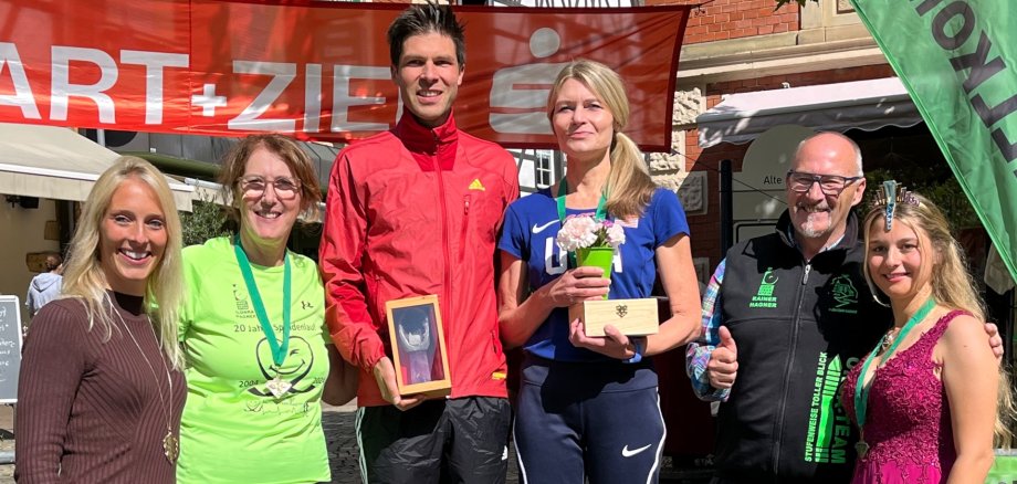 Das Foto zeigt die Gewinner des Hauptlaus 2024, die auf dem Siegerpodest stehen. Sie werden eingerahmt vom Marathonteam Hagner, der Deutschen Edelsteinkönigin sowie Bettina Reiter, der 2. Vorsitzenden des Fördervereins Deutsche Edelsteinstraße.