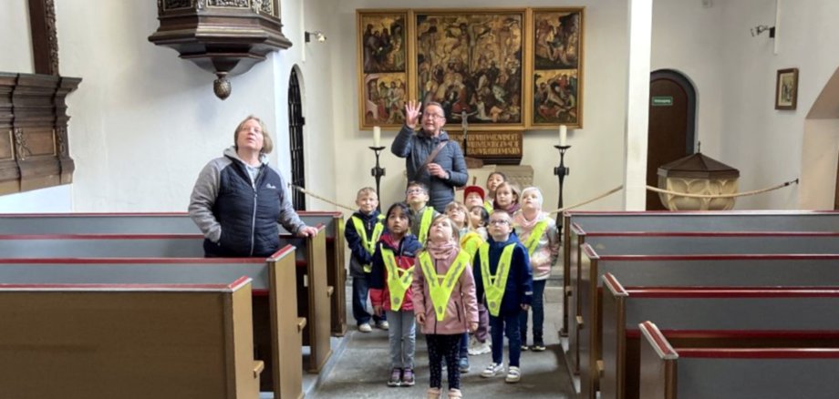 Das Foto zeigt die Gruppe bei der Führung, die Kinder schauen gebannt Richtung Decke.