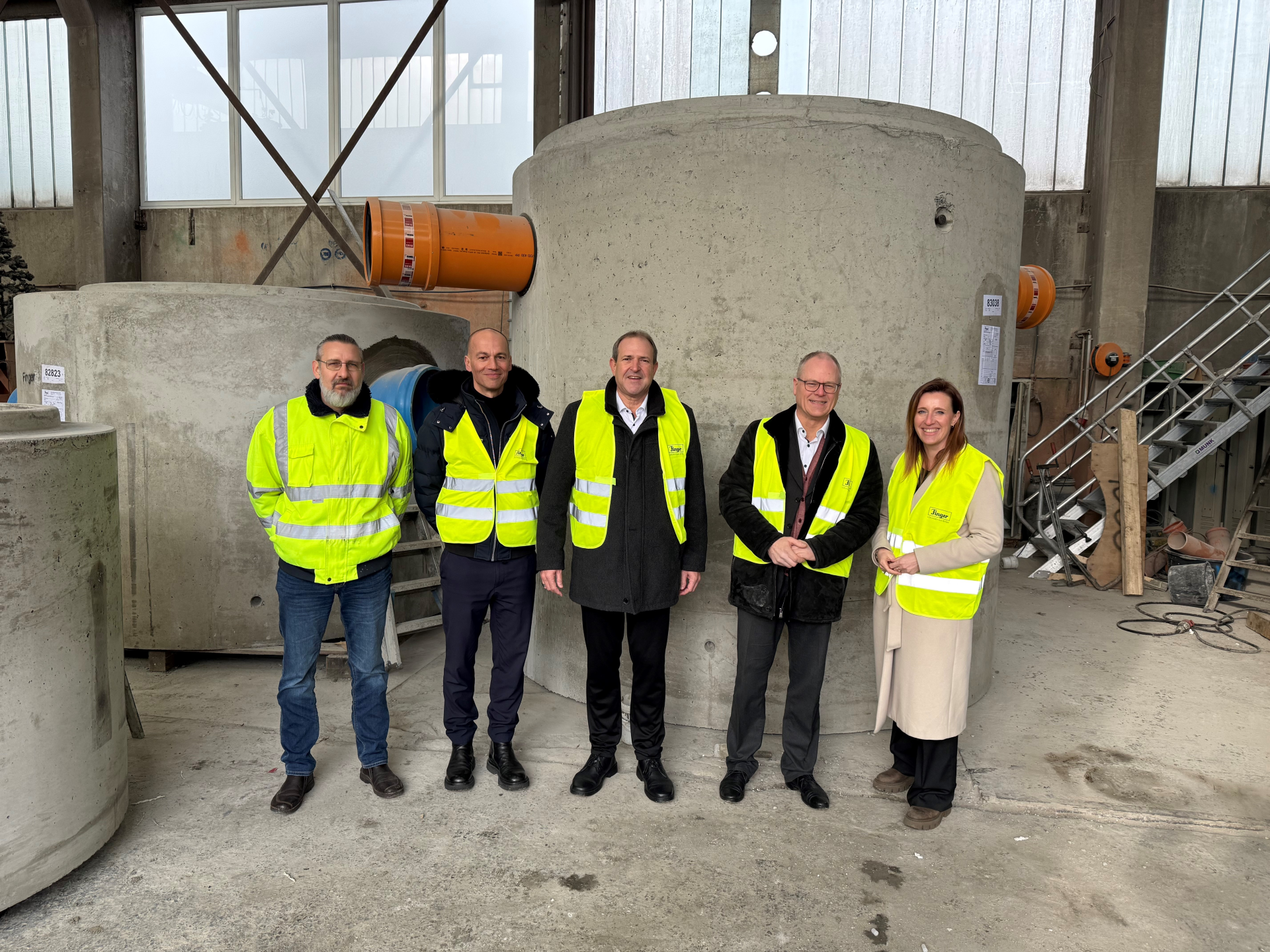 Das Foto zeigt die genannten Personen vor einem Schacht.