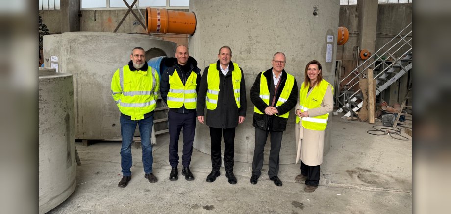 Das Foto zeigt die genannten Personen vor einem Schacht.