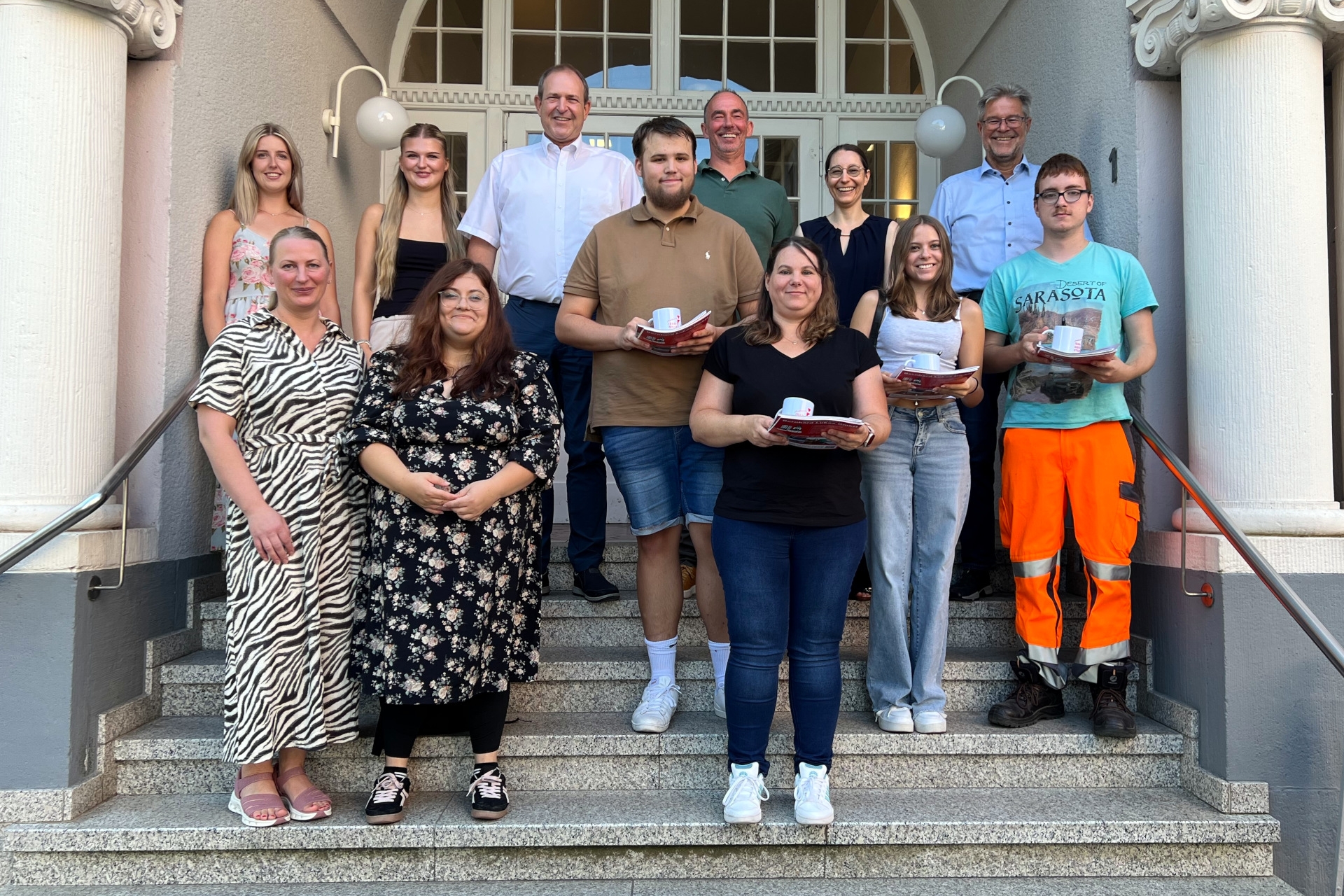 Das Foto zeigt die genannten Personen auf der Treppe vor dem Rathaus.