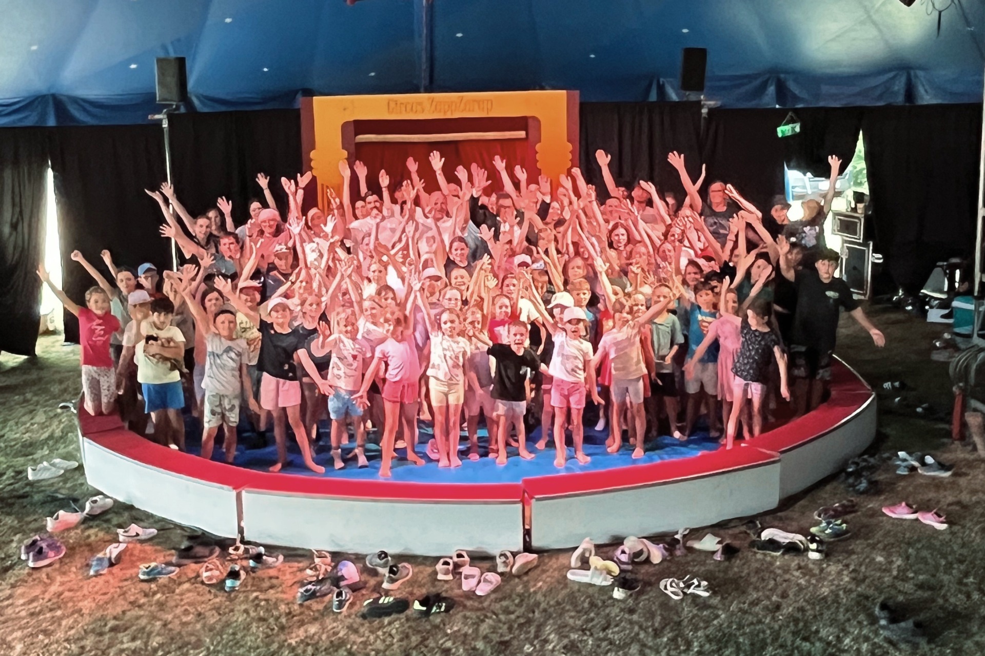 Das Foto zeigt die Kinder mit Betreuern und Gästen in der Manege.