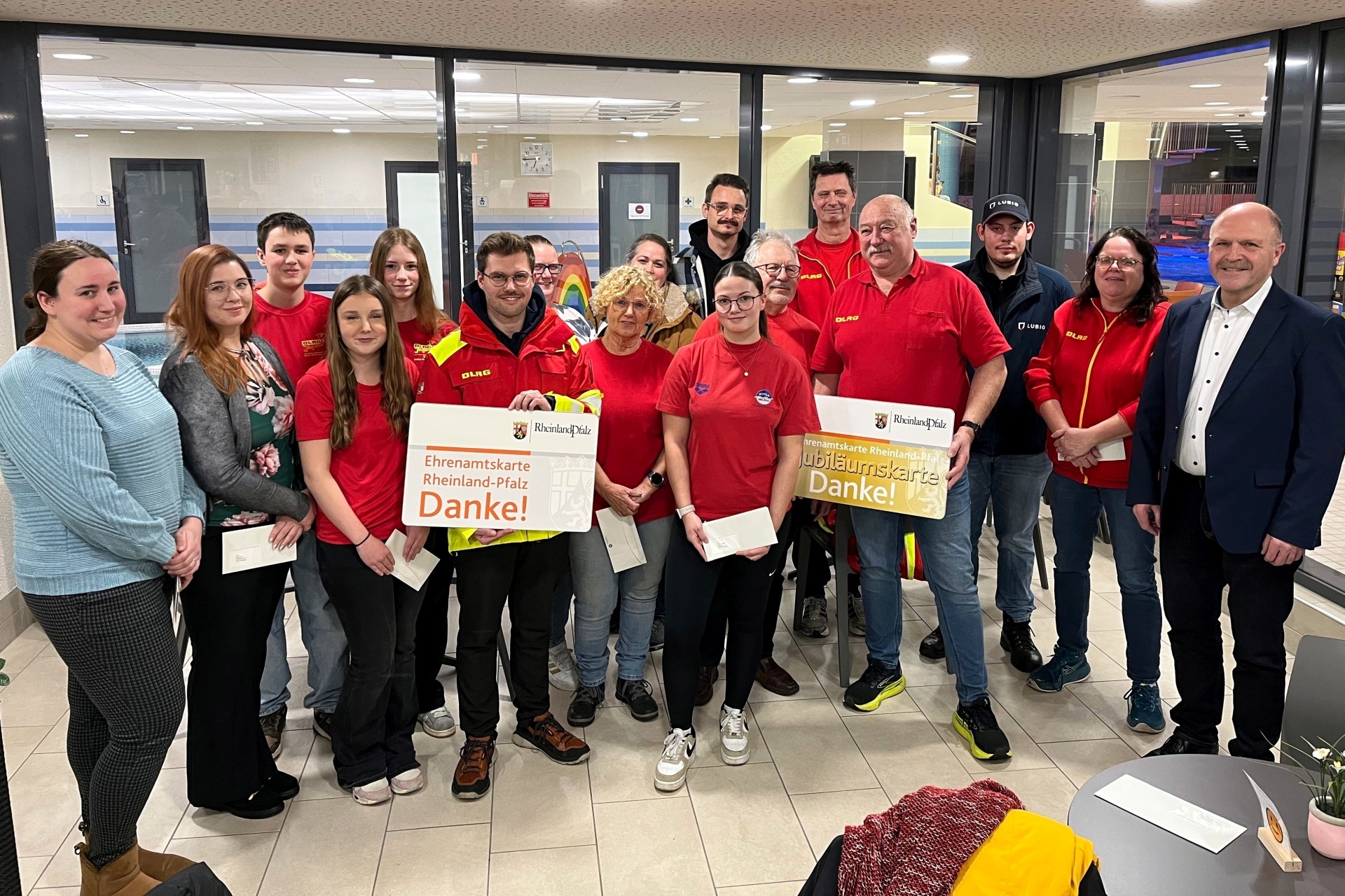 Das Foto zeigt Bürgermeister Marx und die Mitglieder der DLRG im Foyer des Hallenbades.