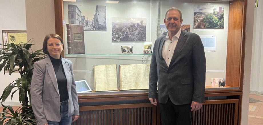 Das Foto zeigt Oberbürgermeister Frank Frühauf und Stadtarchivarin Dr. Svenja Müller vor der Info Vitrine KuLaDig. 