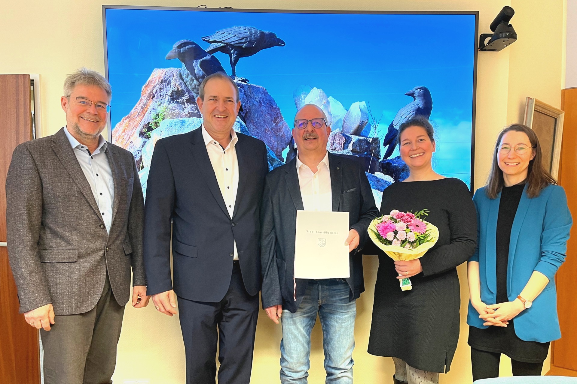 Das Foto zeigt die genannten Personen. Sie stehen im Besprechungszimmer des OB vor einem Bildschirm.