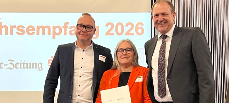 Oberbürgermeister Frank Frühauf überreichte den Kulturpreis der Stadt Idar-Oberstein an Theresia Rommelfanger, Vorsitzende des Musikvereins Tiefenstein, und den Dirigenten Martin Wendel (v. r.). Das Foto zeigt die genannten Personen auf der Bühne in der Messe Idar-Oberstein.