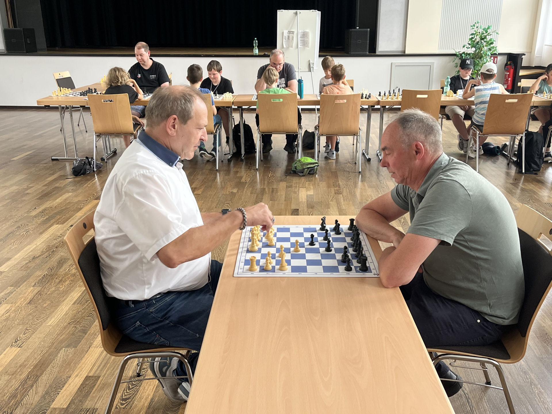 Das Foto zeigt Oberbürgermeister Frank Frühauf und Jugendamtsleiter Michael Schweizer an einem Schachbrett im Rahmen des Sommerferienprogramms.