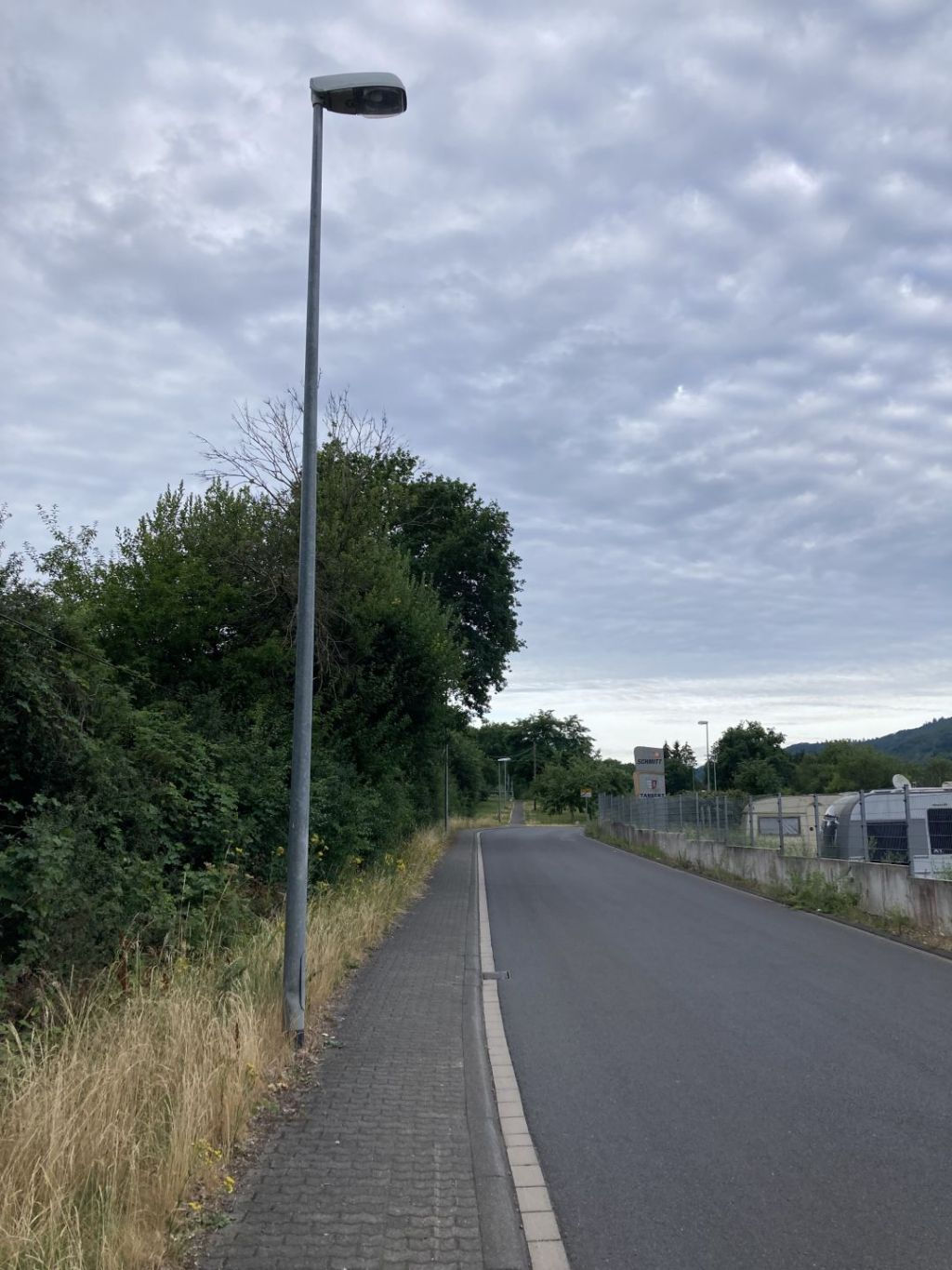 Das Foto zeigt einen Lichtmast, der beschädigt wurde und schief steht. 
