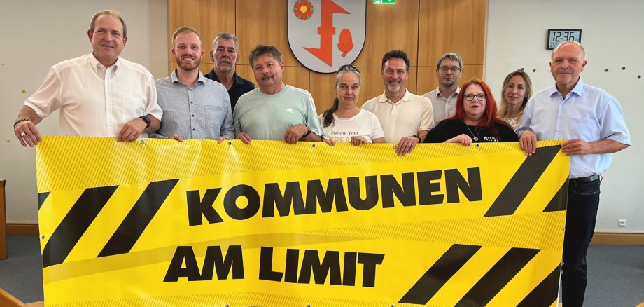 Anlässlich des Aktionstages „Kommunen am Limit“ forderten die Teilnehmer des Pressegesprächs eine nachhaltige und auskömmliche Finanzausstattung der Kommunen. Das Foto zeigt die Teilnehmer des Pressegesprächs, die gemeinsam ein Banner mit der Aufschrift "Kommen am Limit" halten.